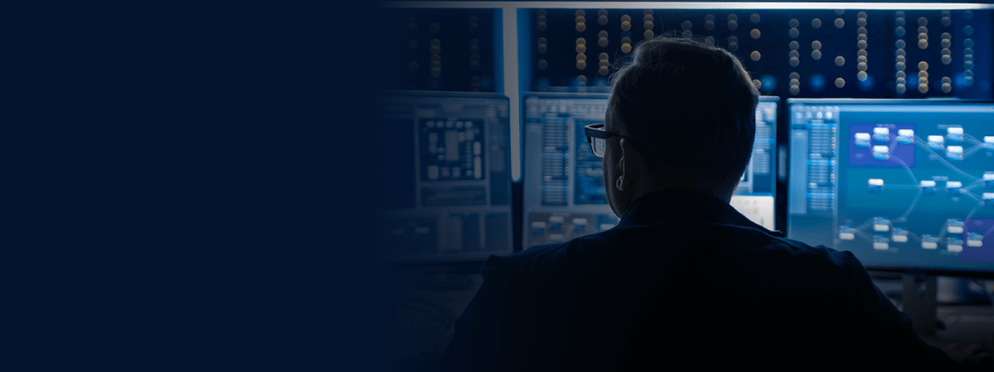 Cybersecurity specialist at work in front of multiple data screens